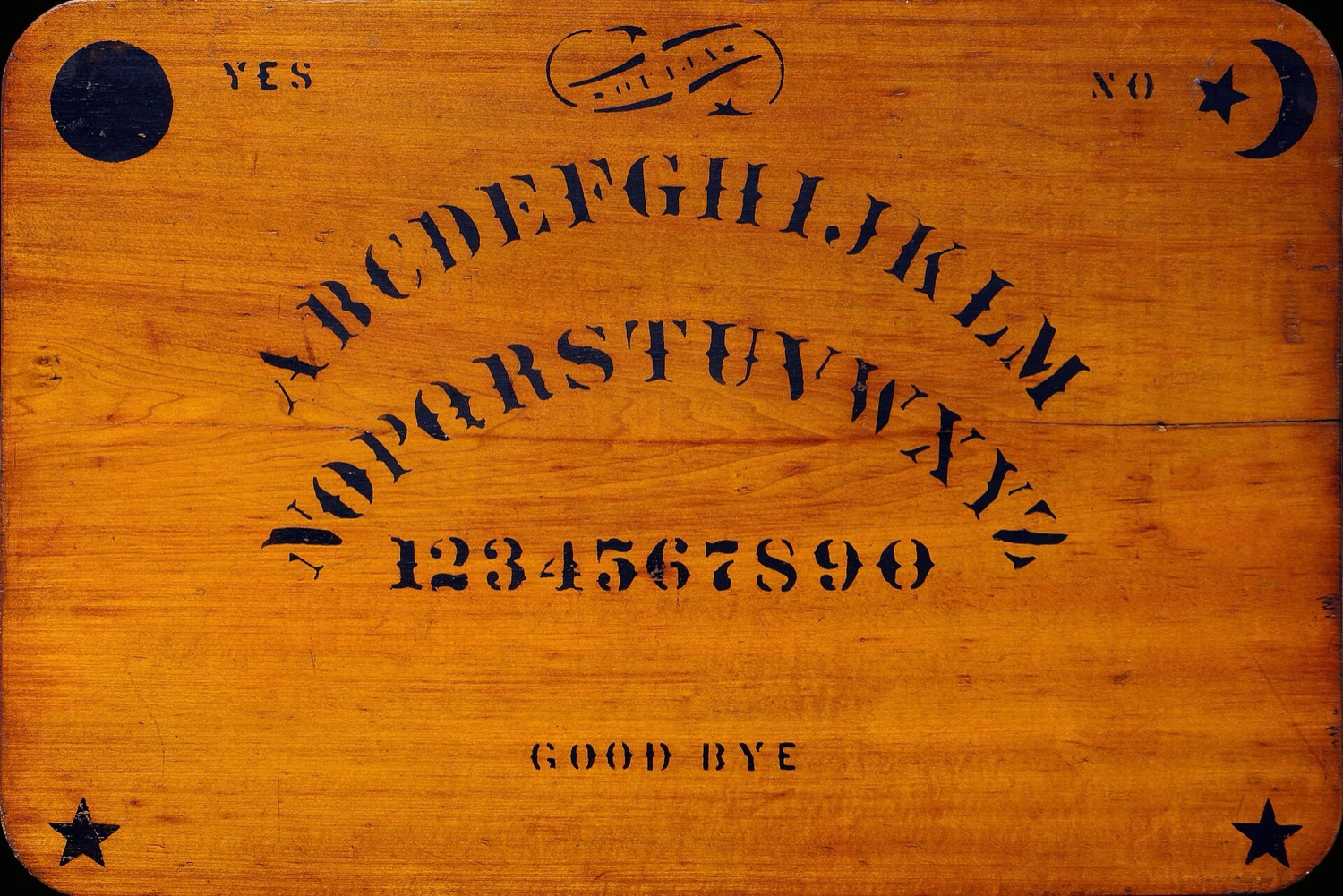 An original Kennard Novelty Company talking board, Baltimore, made before the OUIJA trademark was granted in February 1891: stencilled maple, sun and moon, YES and NO, the alphabet in two arcs, the numerals, GOOD BYE.
